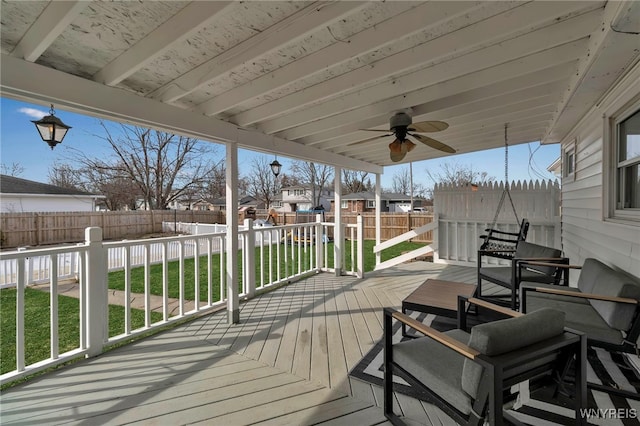 deck featuring a lawn, a ceiling fan, and a fenced backyard