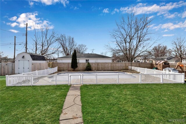 view of yard with a storage shed, a fenced backyard, a fenced in pool, and an outdoor structure