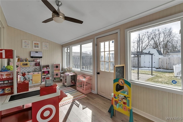 recreation room featuring lofted ceiling, a healthy amount of sunlight, wood finished floors, and a ceiling fan