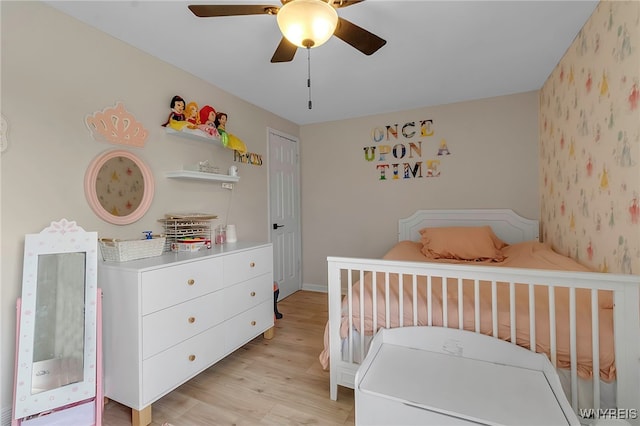 bedroom with light wood finished floors, baseboards, and ceiling fan