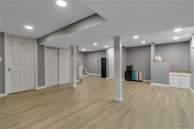 finished basement featuring recessed lighting, stairs, light wood-type flooring, and baseboards