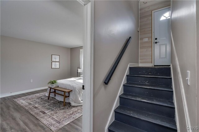 staircase featuring baseboards and wood finished floors