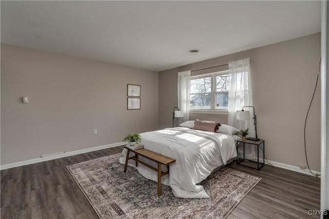 bedroom with visible vents, baseboards, and dark wood-type flooring