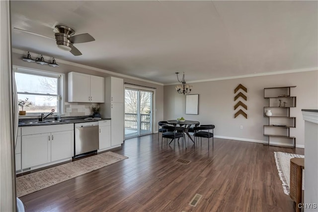 kitchen featuring a sink, stainless steel dishwasher, dark countertops, and dark wood-style floors