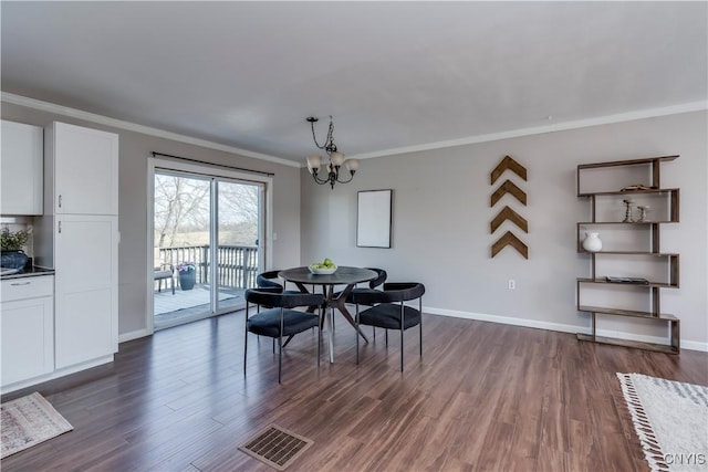 dining space with visible vents, a notable chandelier, dark wood-style floors, and crown molding