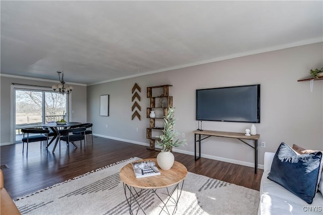 living room featuring visible vents, baseboards, a chandelier, ornamental molding, and wood finished floors