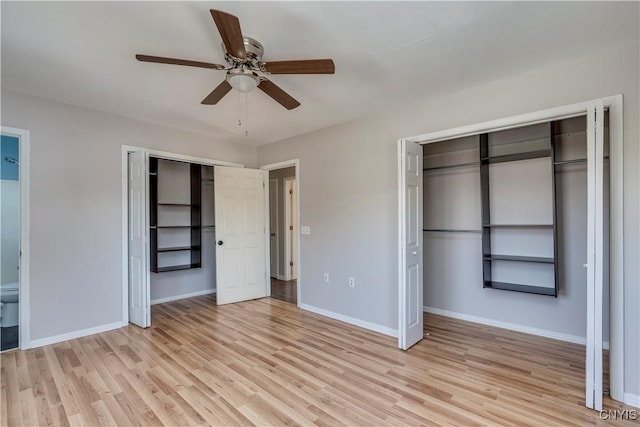 unfurnished bedroom with a ceiling fan, baseboards, multiple closets, and light wood-type flooring