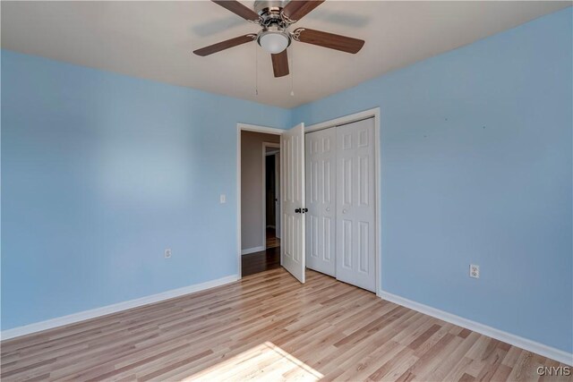 unfurnished room with light wood-style flooring, a ceiling fan, and baseboards