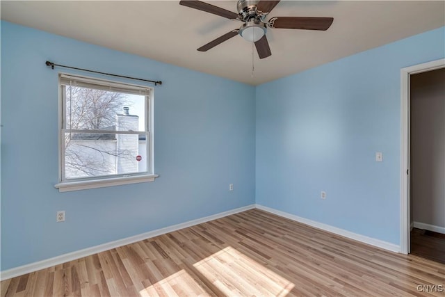 empty room with a ceiling fan, wood finished floors, and baseboards