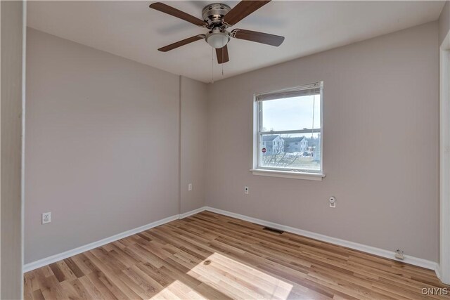 unfurnished room featuring visible vents, baseboards, light wood-style flooring, and a ceiling fan