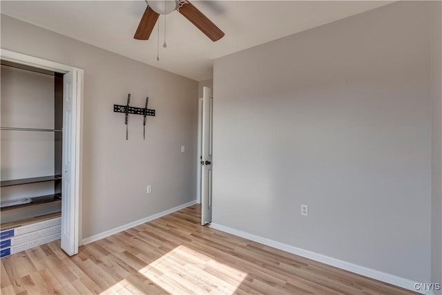 unfurnished bedroom with a closet, ceiling fan, light wood-type flooring, and baseboards