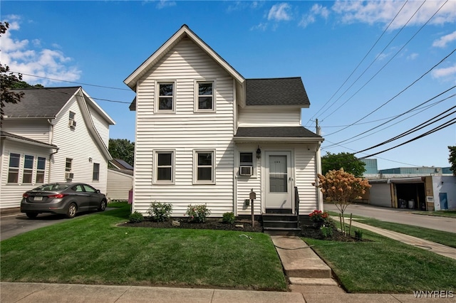 traditional-style home featuring a shingled roof and a front yard