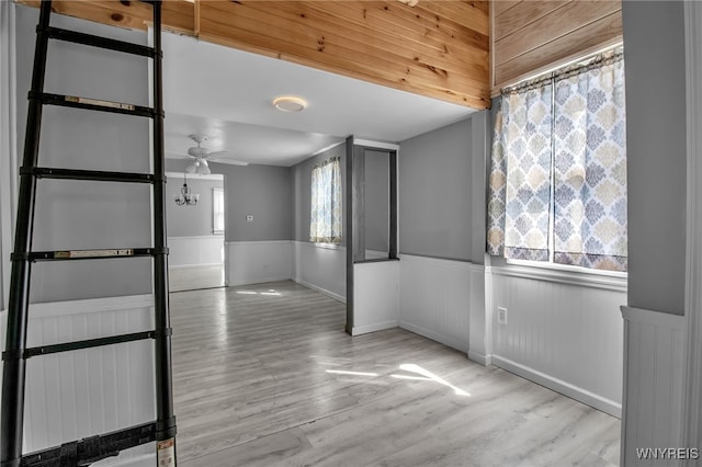 unfurnished room featuring ceiling fan, wood finished floors, and wainscoting