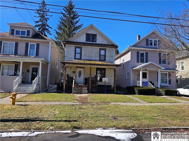 traditional style home with covered porch and a front lawn