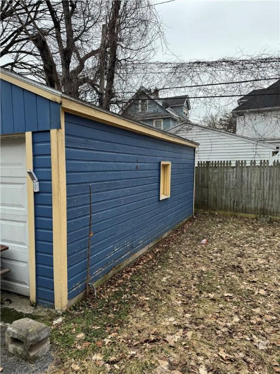 view of side of property featuring an outbuilding, board and batten siding, and fence