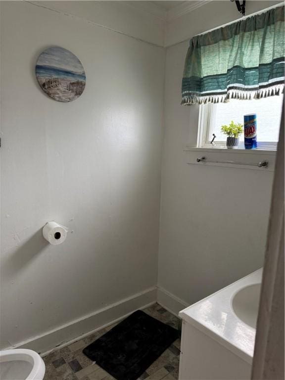 bathroom featuring baseboards, toilet, and vanity