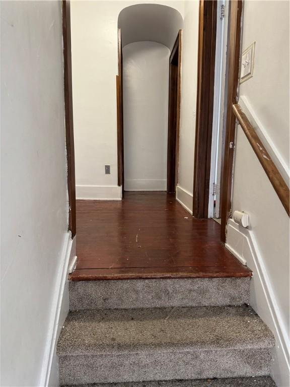 staircase with baseboards and wood finished floors