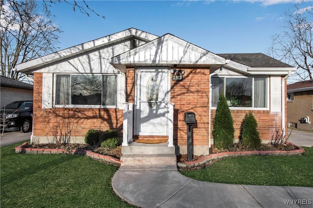 bungalow-style house featuring a front lawn and brick siding