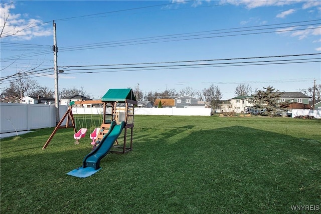 community play area featuring a fenced backyard and a lawn