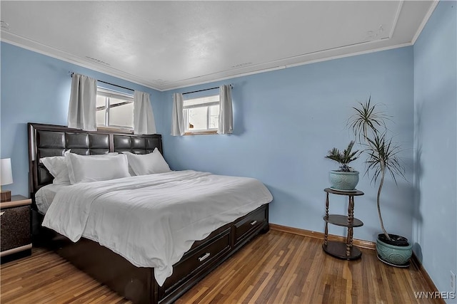 bedroom with ornamental molding, baseboards, and wood finished floors