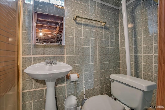 bathroom featuring toilet and tile walls