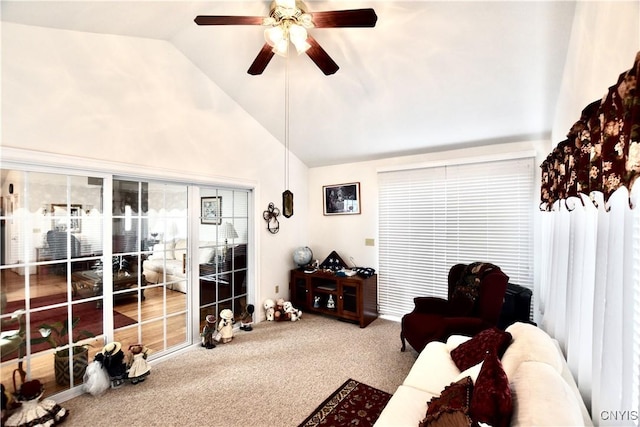 living area with ceiling fan, carpet flooring, and vaulted ceiling