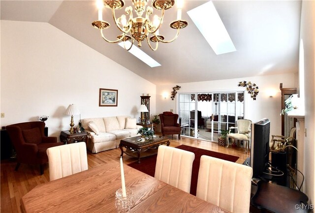 dining area with a skylight, wood finished floors, and high vaulted ceiling