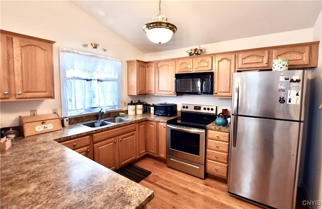 kitchen with a sink, light wood-style floors, appliances with stainless steel finishes, lofted ceiling, and hanging light fixtures