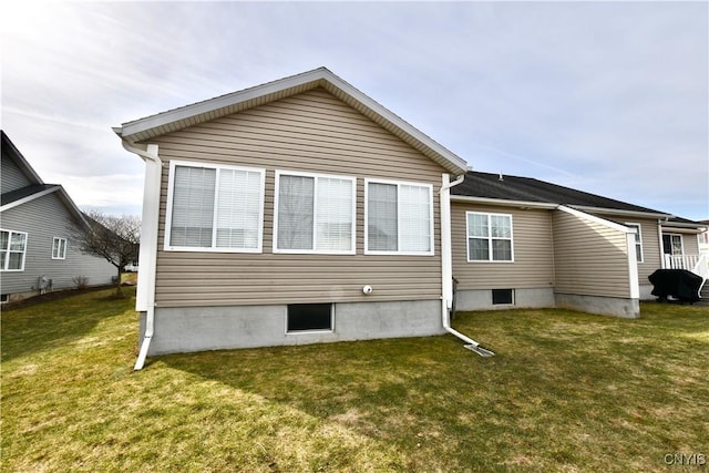 rear view of property featuring a lawn