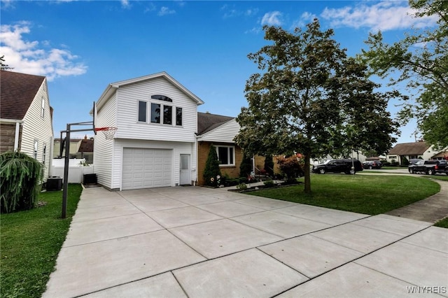 view of front of home with driveway, cooling unit, an attached garage, a front yard, and brick siding