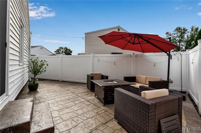 view of patio / terrace with an outdoor living space with a fire pit and a fenced backyard