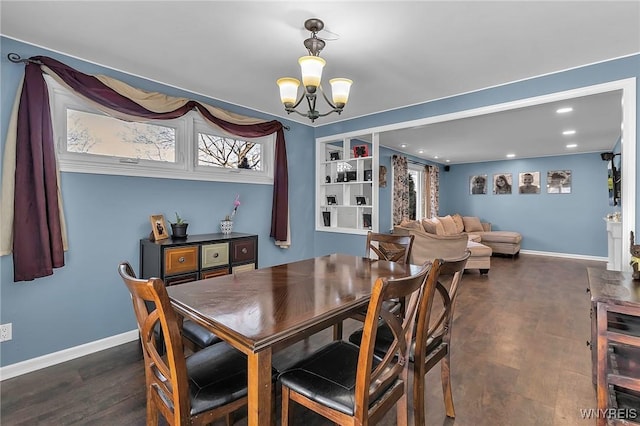 dining area with a chandelier, baseboards, and dark wood-style flooring