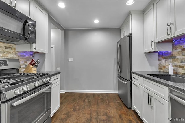 kitchen featuring recessed lighting, stainless steel appliances, dark wood finished floors, and white cabinetry