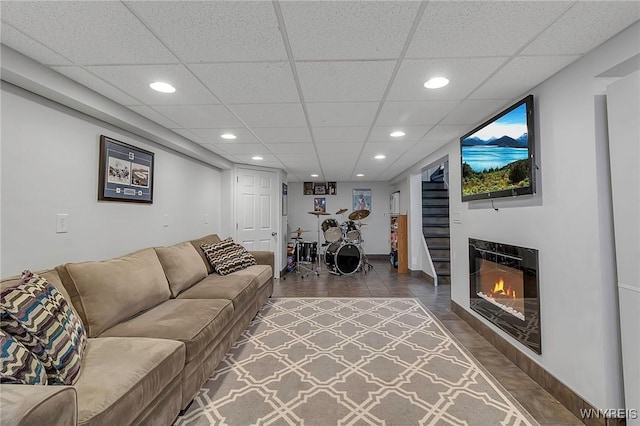 living room with a glass covered fireplace, recessed lighting, and baseboards