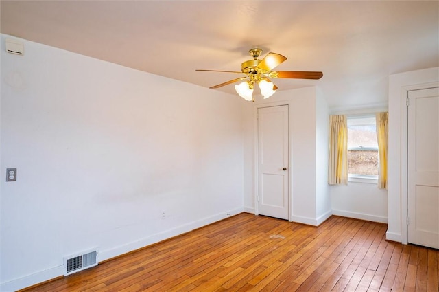 unfurnished room with visible vents, a ceiling fan, light wood-type flooring, and baseboards