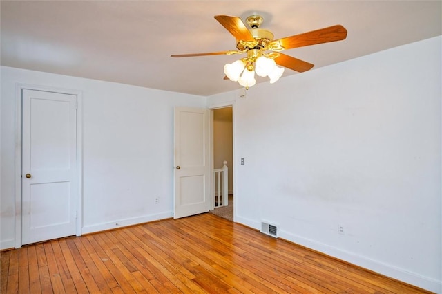 spare room featuring visible vents, baseboards, ceiling fan, and light wood finished floors