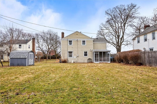 back of house with an outbuilding, fence, a shed, a yard, and a sunroom