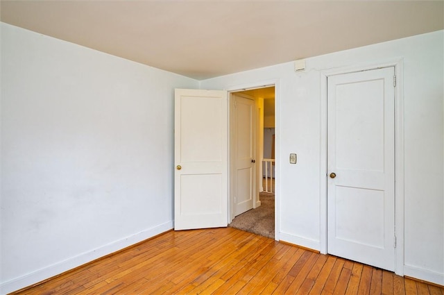 unfurnished bedroom featuring light wood-style flooring and baseboards