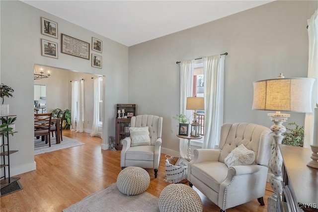 living area featuring light wood-type flooring, baseboards, an inviting chandelier, and visible vents