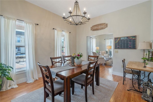 dining space with an inviting chandelier, light wood-type flooring, and baseboards