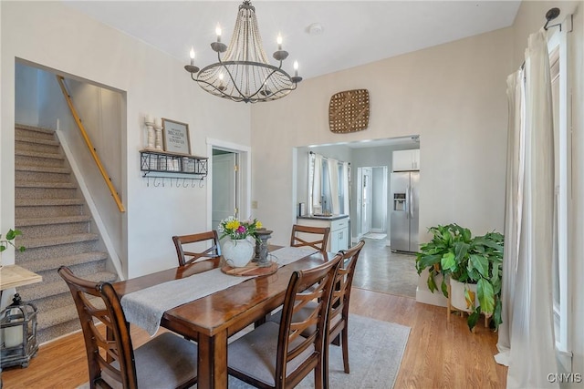 dining room featuring a chandelier, stairs, and light wood-type flooring