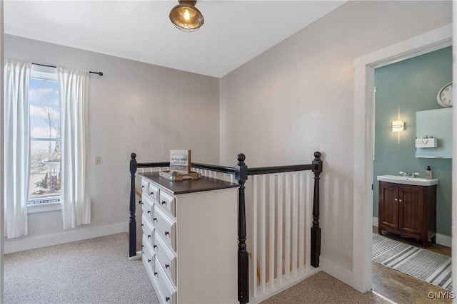 hallway featuring plenty of natural light, an upstairs landing, and light carpet