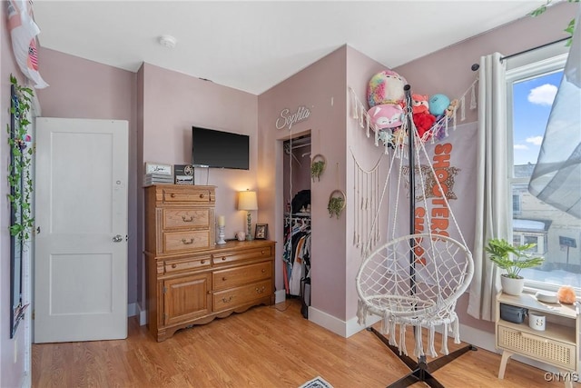 bedroom with a closet, baseboards, and light wood-style floors