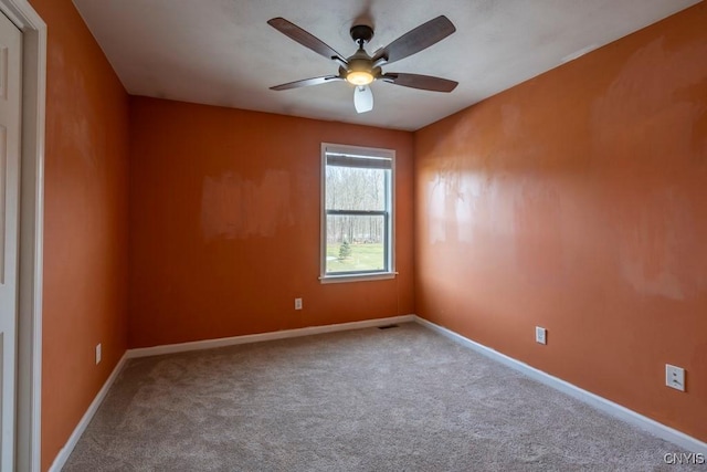 spare room with a ceiling fan, carpet, and baseboards