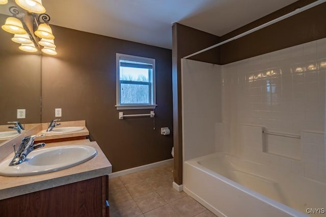 bathroom with an inviting chandelier, tile patterned floors, baseboards, and a sink