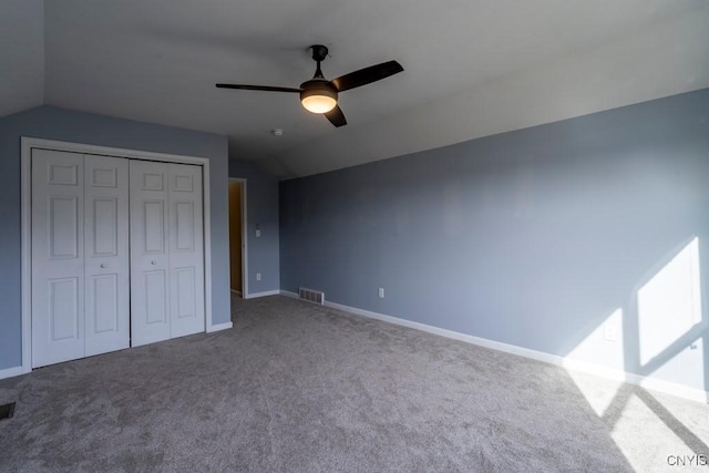 unfurnished bedroom featuring lofted ceiling, carpet, visible vents, and a closet