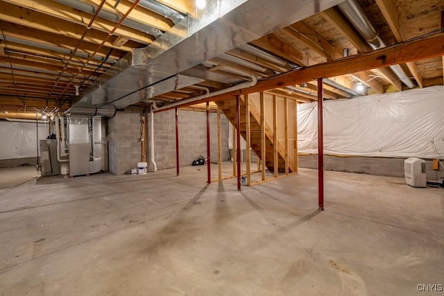 unfinished basement featuring heating unit and water heater