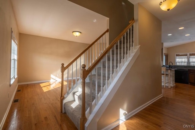 staircase with visible vents, recessed lighting, wood finished floors, and baseboards