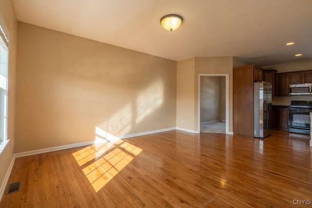 unfurnished living room with visible vents, recessed lighting, baseboards, and wood finished floors