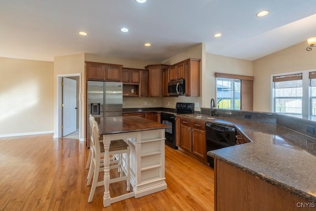 kitchen with open shelves, light wood-type flooring, recessed lighting, black appliances, and a sink